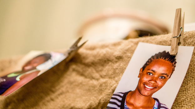 Auf einem Tisch liegen eine Klammer, ein Passfoto im Passformat und ein Stoffstück auf der rechten Seite, mit einem unscharfen Hintergrund und linker Seite.