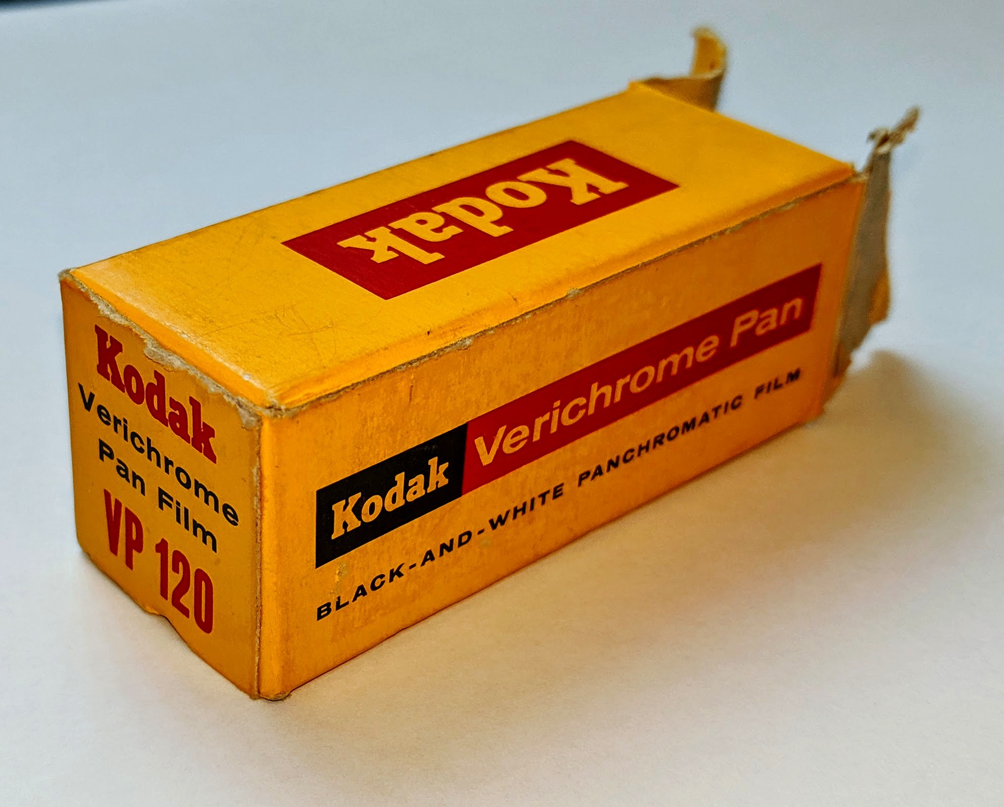 Gelber Kodak Verichrome Filmkarton mit Text auf einem weißen Tisch.