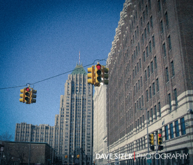 Mehrere Ampeln an Masten vor Gebäuden.