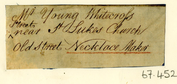 Ein abgegriffenes, leicht zerknülltes Stück Papier mit verblasster Handschrift in Schreibschrift, das "Alter Straße Schmuckmacher" lautet.
