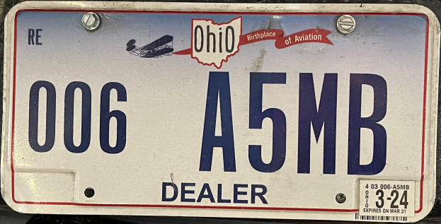 Nummernschild am Heck eines Autos mit alphanumerischen Zeichen.