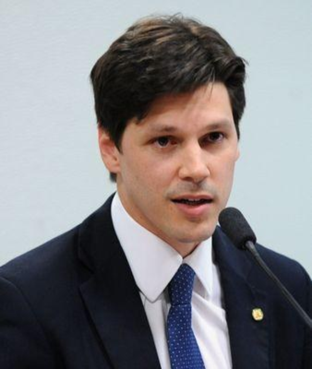 Ein Mann im Anzug spricht in ein Mikrofon, wahrscheinlich spricht er die Genehmigung eines Gesetzes durch die Regierung an.