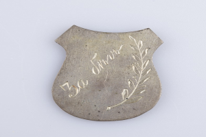 Ein silbergerändertes Abzeichen mit Lorbeerkranz und der Aufschrift "50-jähriges Jubiläum" auf einem weißen Hintergrund.