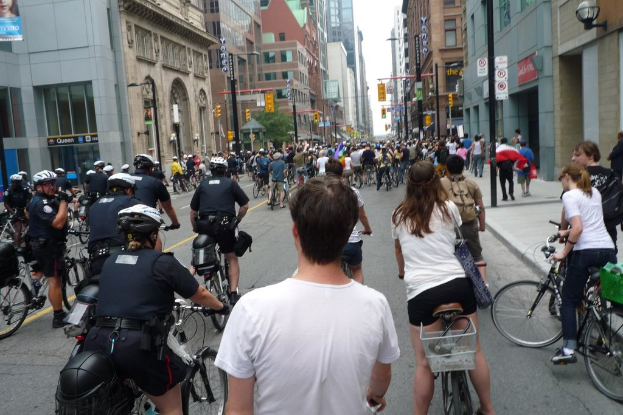 Gebäude säumen eine Straße, auf der wenige Menschen Fahrrad fahren.
