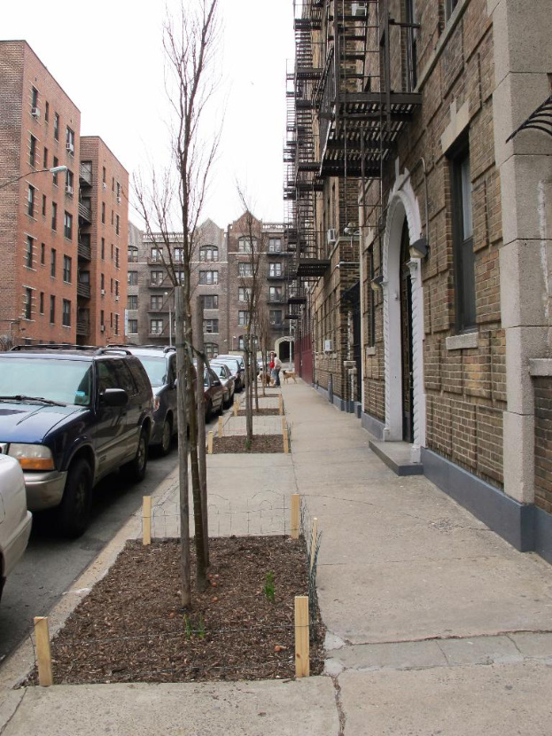 Eine spärliche Stadtlandschaft mit einigen Autos und Gebäuden in der rechten Ecke und einigen anderen Gebäuden in der linken Ecke.