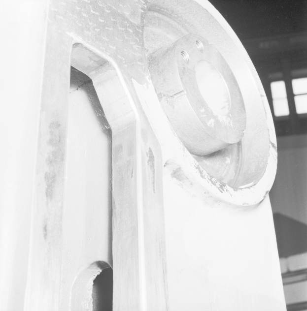 Ein Nahaufnahme eines glänzenden, detaillierten Fräsen in einer Fabrik, mit einer Wand und Fenstern im Hintergrund.