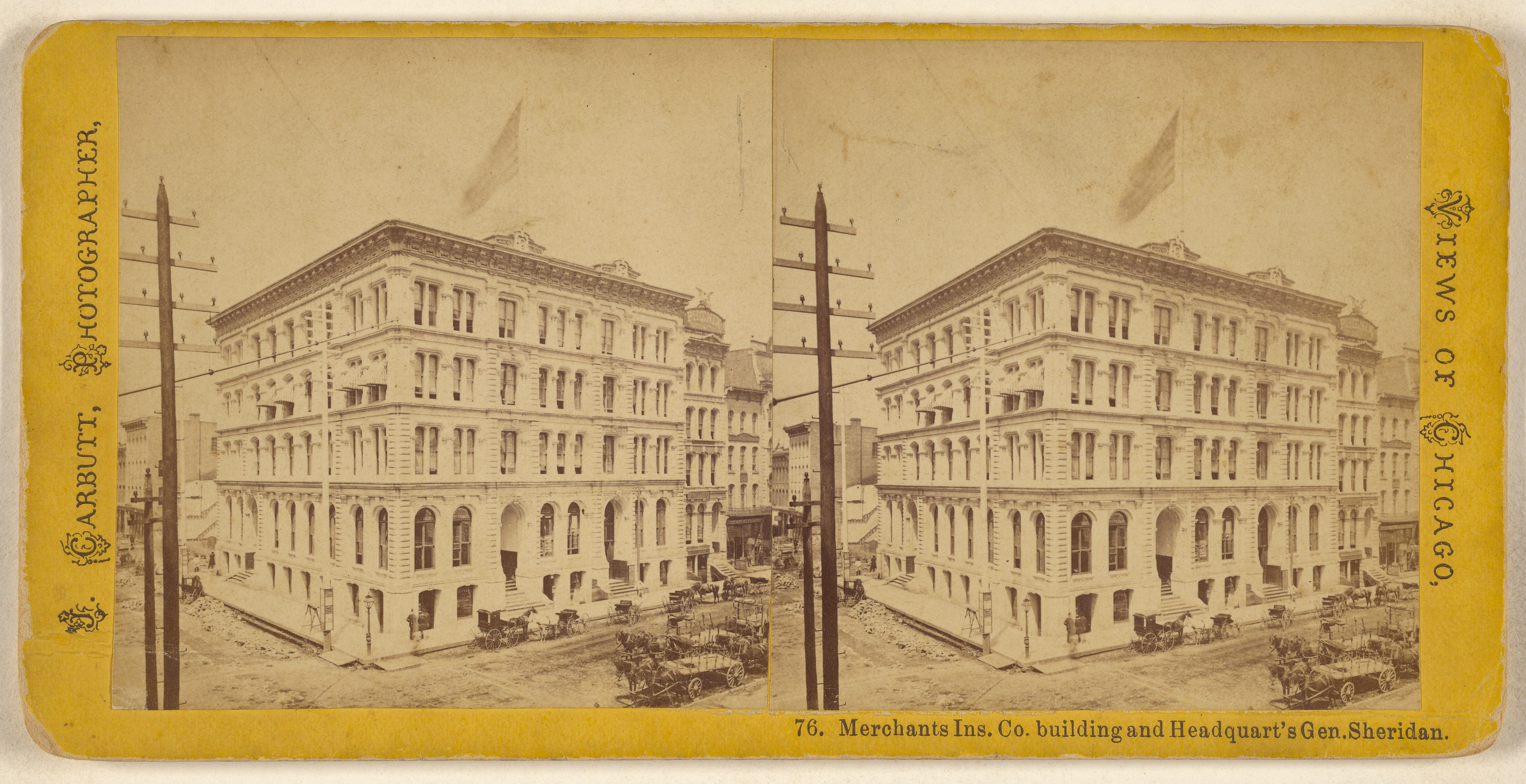 Ein altes Foto einer Straße mit Gebäuden, Strommasten und Karren, das Fenster an den Gebäuden und Text auf dem Bild zeigt.