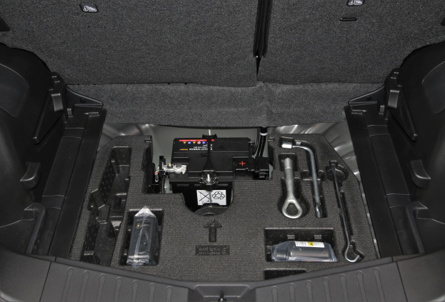 Das Kofferraum eines Autos ist offen und zeigt eine Vielzahl von Werkzeugen und anderen Gegenständen im Inneren.