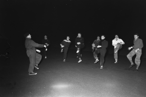 Eine Gruppe von Männern in Schuhen auf einer Bühne in einem Schwarz-Weiß-Setting, wahrscheinlich während einer Vorstellung.
