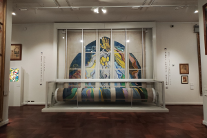 Eine Galerie im Museum of Modern Art in New York City, die zahlreiche Gemälde zeigt, darunter eines in einer Glasvitrine, gerahmte Kunst an den Wänden und Deckenbeleuchtung.