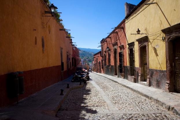 Eine leere Straße mit zahlreichen parkenden Fahrrädern, umgeben von mehreren Gebäuden, mit einem prominenten Gebäude im Vordergrund.