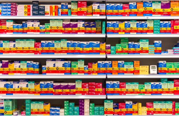 Ein Apothekenschrank voller verschiedener Medikamente, darunter Schachteln und andere Gegenstände, die ordentlich auf den Regalen angeordnet sind.