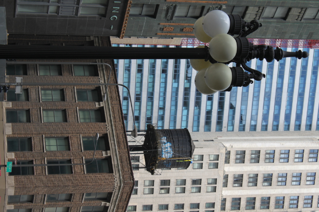 Einige Gebäude mit Masten, Lampen, Fenstern und einem Wassertank oben drauf.