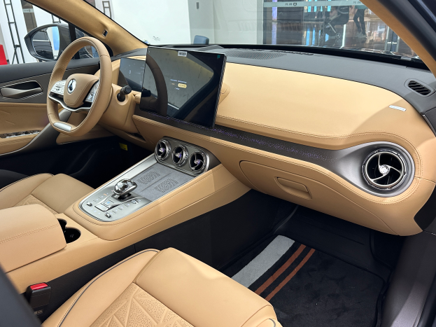 Das Innere eines Mercedes-Benz S-Klasse Limousinen auf der Internationalen Automobil-Ausstellung in Frankfurt, mit einem Lenkrad, Armaturenbrett, Bildschirmen, Knöpfen, Sitzen, Seitenspiegeln und Glasfenstern, durch die Menschen, Gebäude und andere Objekte im Hintergrund zu sehen sind.