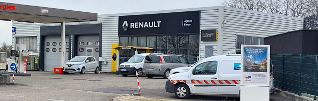 Eine Renault-Vertretung mit parkenden Autos vorne, umgeben von einem Metallzaun.