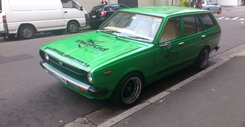 Eine Person steht neben einer Straße mit Fahrzeugen.