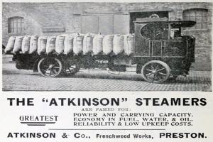 Anzeige für Atkinson-Dampfwagen, die ein Fahrzeug auf einer Straße mit Gepäck, ein Gebäude im Hintergrund und den Text "Atkinson-Dampfwagen - Die größte Kraft und Tragfähigkeit" unten zeigt.