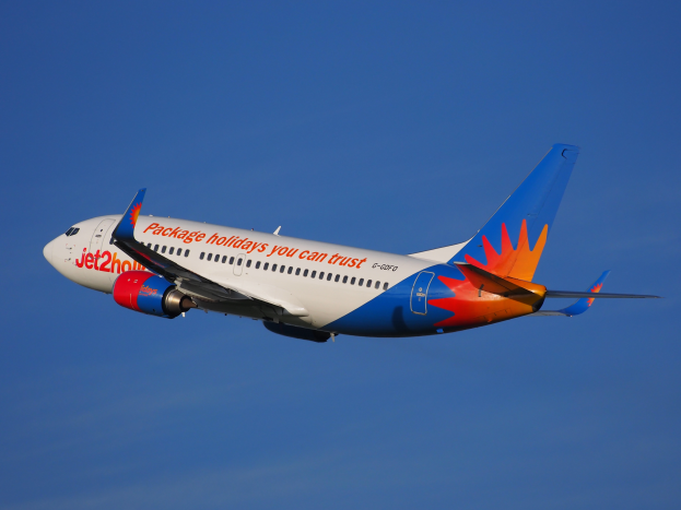 Ein Airbus A320-200 der Jet2holidays im Flug, mit einer weiß-blauen-orangen-roten Lackierung gegen einen blauen Himmel.