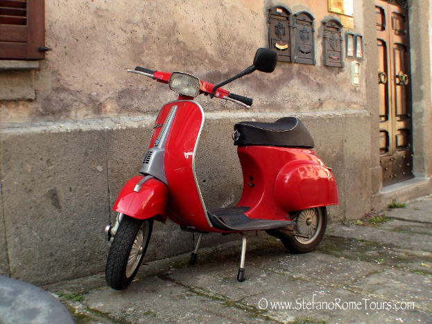 Ein roter E-Scooter steht vor einem Haus mit Tür und Fenstern, mit einer Straße unten im Bild und etwas Text.