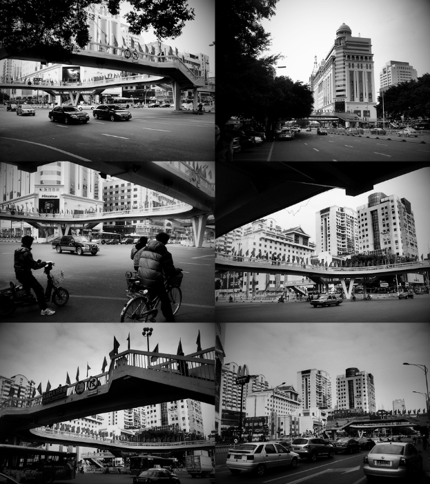 Autos und Fahrräder sind unter einer Brücke zu sehen, mit ein paar Fahrzeugen vor einem Gebäude.