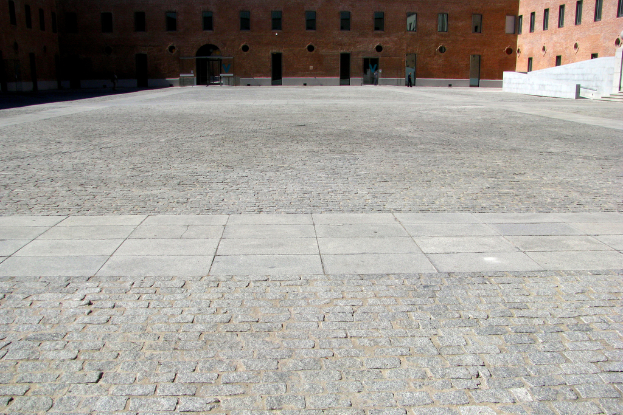 Ein Gebäude mit Glasfenstern oben auf einem Bild, mit Land darunter.