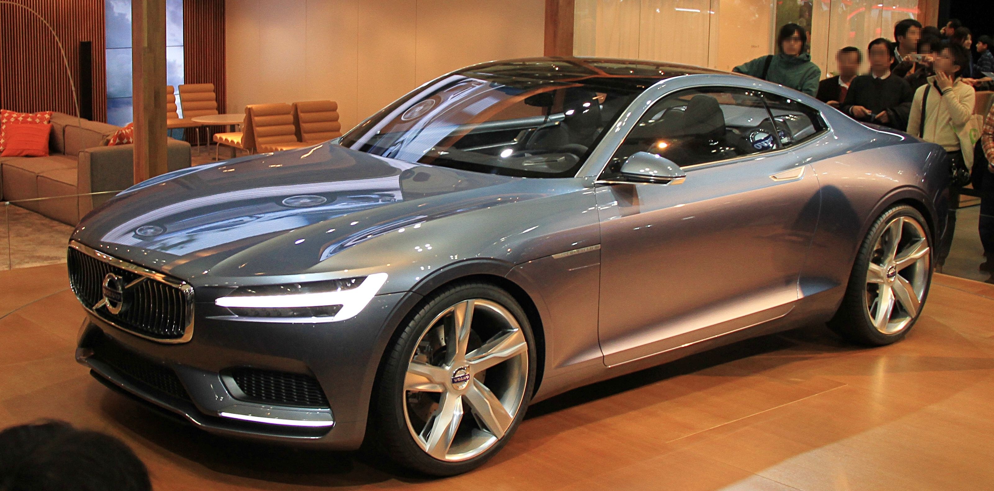 Ein elegantes Volvo-Konzeptfahrzeug mit glänzender schwarzer Lackierung und Chromakzenten auf der Internationalen Automobil-Ausstellung in Frankfurt, umgeben von Menschen, die sein modernes Design und luxuriöses Inneres bewundern.