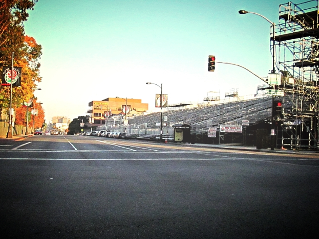 Eine Straße mit einer Verkehrsampel und Equipment auf der rechten Seite, Warnschilder und mehrere Fahrzeuge auf der linken Seite sowie Bäume im Hintergrund.