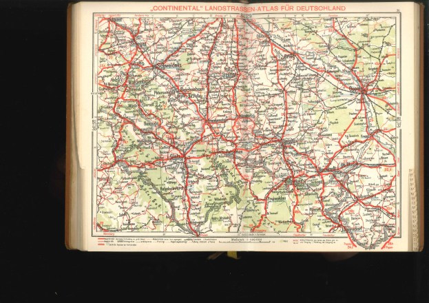 Offenes Buch mit einem detaillierten Plan von Deutschlands Straßen und Autobahnen auf schwarzem Hintergrund.