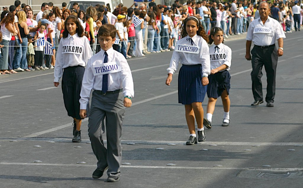 Eine Gruppe von Menschen, die auf der Straße gehen und Abzeichen auf ihren Hemden tragen, mit einer großen Menge, die sich um die Straße sammelt.