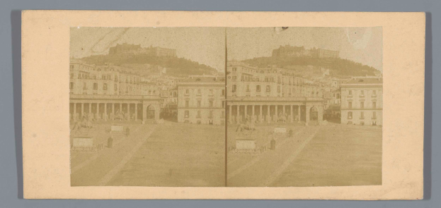 Ein Schwarz-Weiß-Foto einer Stadtstraße mit Gebäuden, Menschen und einem Hügel im Hintergrund aus der Stereosicht-Sammlung der Nationalarchivs von Italien.